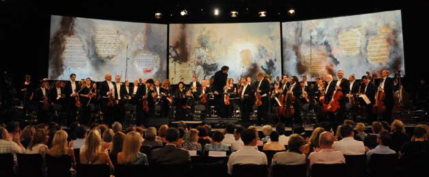 Das Mnchner Rundfunkorchester musiziert unter den Bildern von Heidi Winkler. Foto: Ingrid Grossmann